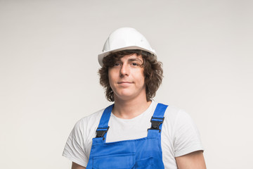 Construction, building and workers concept - Closeup portrait of handsome curly white man in builders helmet.