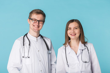 Fototapeta premium Male and female doctors in white gowns in studio