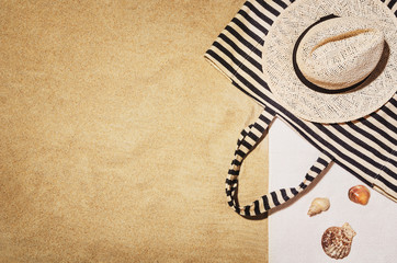 Top view of sandy beach with towel frame and summer accessories. Background with copy space and...