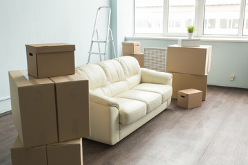 Light room with sofa and boxes which is prepared for moving.