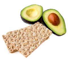 Isolated avocado fruit. Two halves of avocadoes with wholegrain crispy bread  isolated on white...