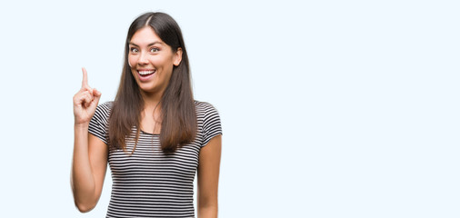 Young beautiful hispanic woman pointing finger up with successful idea. Exited and happy. Number...