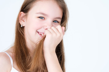 emotion face. playful mischievous smiling child covering her mouth and teeth with hair. little girl portrait on white background. mood feelings personality and facial expression concept