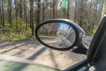 Dust lifted by the car at high speed from behind through the rearview mirror