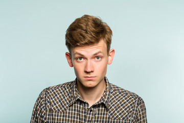 whimsical look. impressed man with raised eyebrows. portrait of a young guy on light background. emotion facial expression. feelings and people reaction.