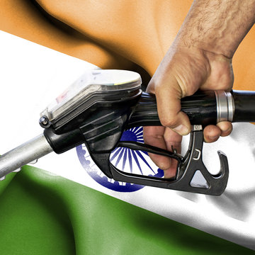 Gasoline consumption concept - Hand holding hose against flag of India