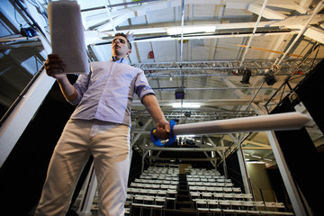 Young man with paper sword reading his speech during stage repetition process