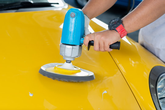 Fototapeta Car detailing series: Polishing yellow sports car hood