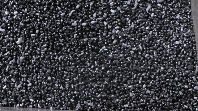 Plastic black gray granulated crumb. Manufacture of plastic water pipes of the factory. Process of making plastic tubes on the machine tool with the use of water and air pressure.