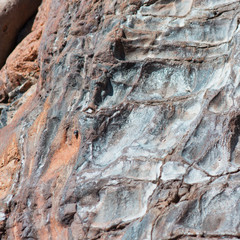 A large slab of stone on the beach weathered by the ocean waves