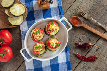 Slices of eggplant with minced meat, tomatoes and cheese ready for baking