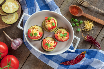 Slices of eggplant with minced meat, tomatoes and cheese ready for baking