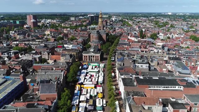 Aerial footage of Groningen city center flight towards AA Church moving over Groningen Markt the marketplace located at shopping street showing the colorful market stand roofs and shops 4k quality