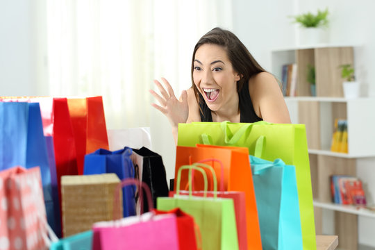 Amazed woman looking at multiple shopping bags