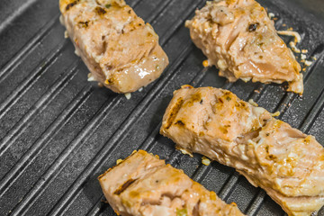 Slices of roasted salmon in a grill pan