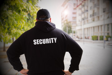security man in a sunny day checking the city