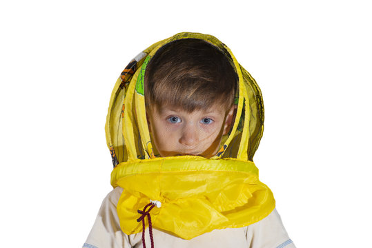 A boy in a yellow mask from bees looks at the camera in the studio, on an isolated background.