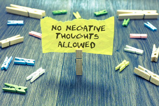 Handwriting text No Negative Thoughts Allowed. Concept meaning Always positive motivated inspired good vibes Paperclip hold written torn page many clips laid on bluish wooden floor.