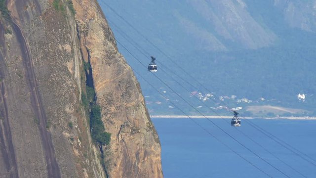 Sugarloaf Mountain cable cars passing each other with mountain and ocean as background, Rio de Janeiro, Brazil