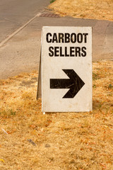 Large sign with black letters on a white background with an arrow pointing to the right and the...