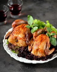 Two baked chicken with lettuce on white plate and black background.
