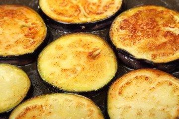 Sliced eggplants fry in a pot with oil