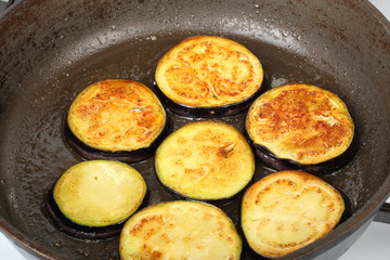 Sliced eggplants fry in a pot with oil