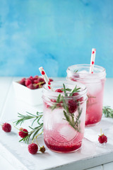 SOFT DRINKS. Refreshing summer drink raspberry with rosemary and ice. Glasses with cold and healthy beverage in a rustic style. Copy space.