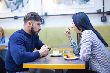 Happy loving couple enjoying breakfast in a cafe. Love, dating, food, lifestyle