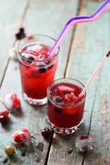 Non alcoholic cold drink. Cherry sangria made on cherry juice, soda and ice in glass on rustic blue table