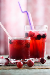 Refreshing non alcoholic beverage. Sangria, cold drink of cherry juice and soda with ice on blue background