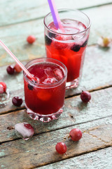 Healthy non alcoholic beverage sangria. Refreshing cold drink of cherry juice and soda soda with ice on rustic blue background