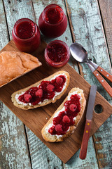 Healthy snack. Raspberry jam, ricotta and raw berries on ciabatta bread on blue background
