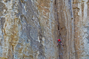climber in a red t-shirt climbs the mountain