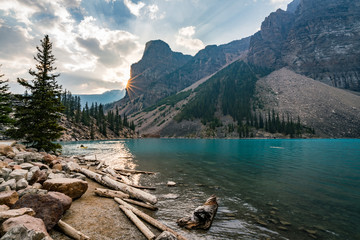 Sunrise with turquoise waters of the Moraine lake with sin lit rocky mountains in Banff National...
