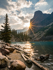 Sunrise with turquoise waters of the Moraine lake with sin lit rocky mountains in Banff National Park of Canada in Valley of the ten peaks.