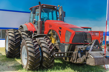 modern tractor for agriculture on the farm with a powerful motor, the flagship of the modern agricultural industry - 214509825