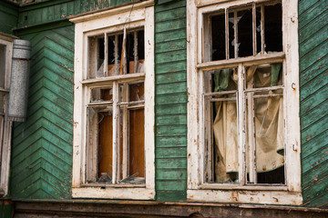 Fototapeta na wymiar Windows with broken glass in an abandoned house