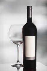 Bottle of black wine and empty glass