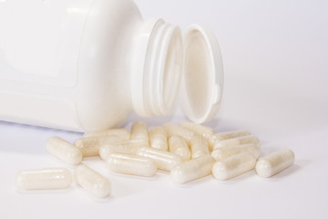 White medicine or supplement capsules on white background