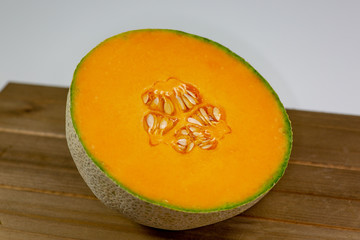 Half a cantaloup sitting on the kitchen table waiting to be eaten