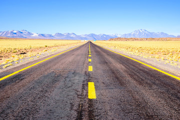 A long straight road that crosses the Atacama desert. Road to highlands lagoons. Lagunas altiplanicas, Chile, South America.