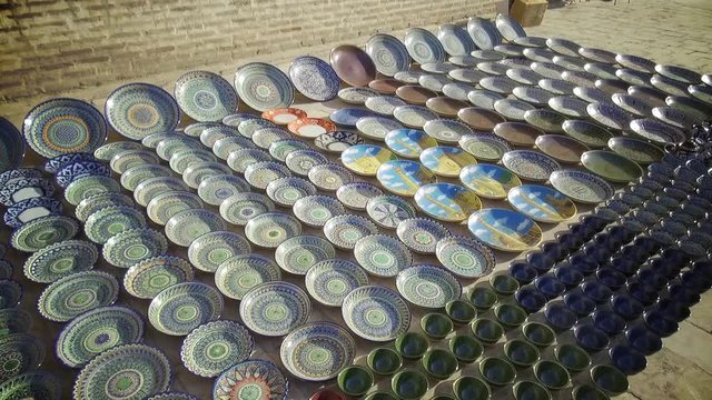 Color footage of some handmade Uzbekistan plates for sale.