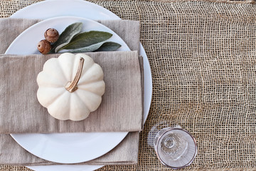 Thanksgiving Day or Halloween place setting with mini white pumpkins, Lamb's Ears leaves, and...