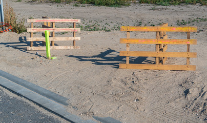Absperrung einer Durchfahrt mit Paletten auf Sand