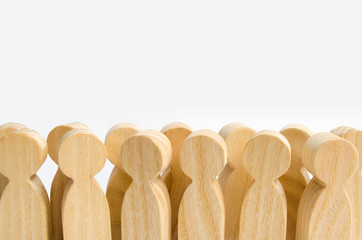 A crowd of wooden figures of people standing on a white background. The concept of the population and the density of the crowd. Herd feeling, statistical data. Spectators, fans. Copy Space