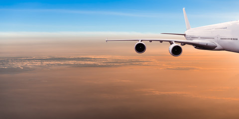 Fototapeta na wymiar Big commercial airplane flying above dramatic clouds.