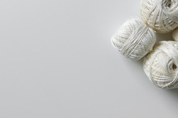 Beige and white hanks for a crochet on a white table background with copy space.