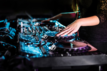 Dj mixes the track in the nightclub at a party