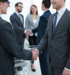 Two businessmen handshaking, congratulating on promotion.
